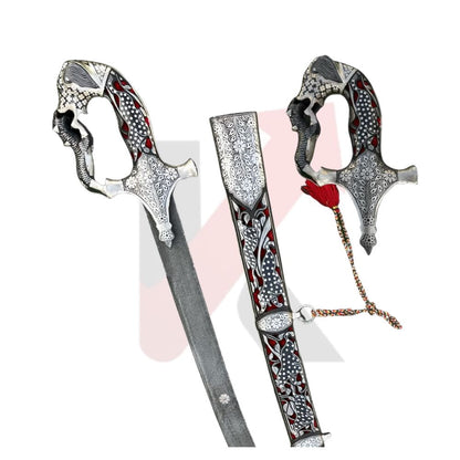 An ornate silver-colored ceremonial sword with intricate red and black floral engravings on the hilt and scabbard, displayed alongside its matching sheath on a white background. Imperial mughal shamshir by kraftmart 