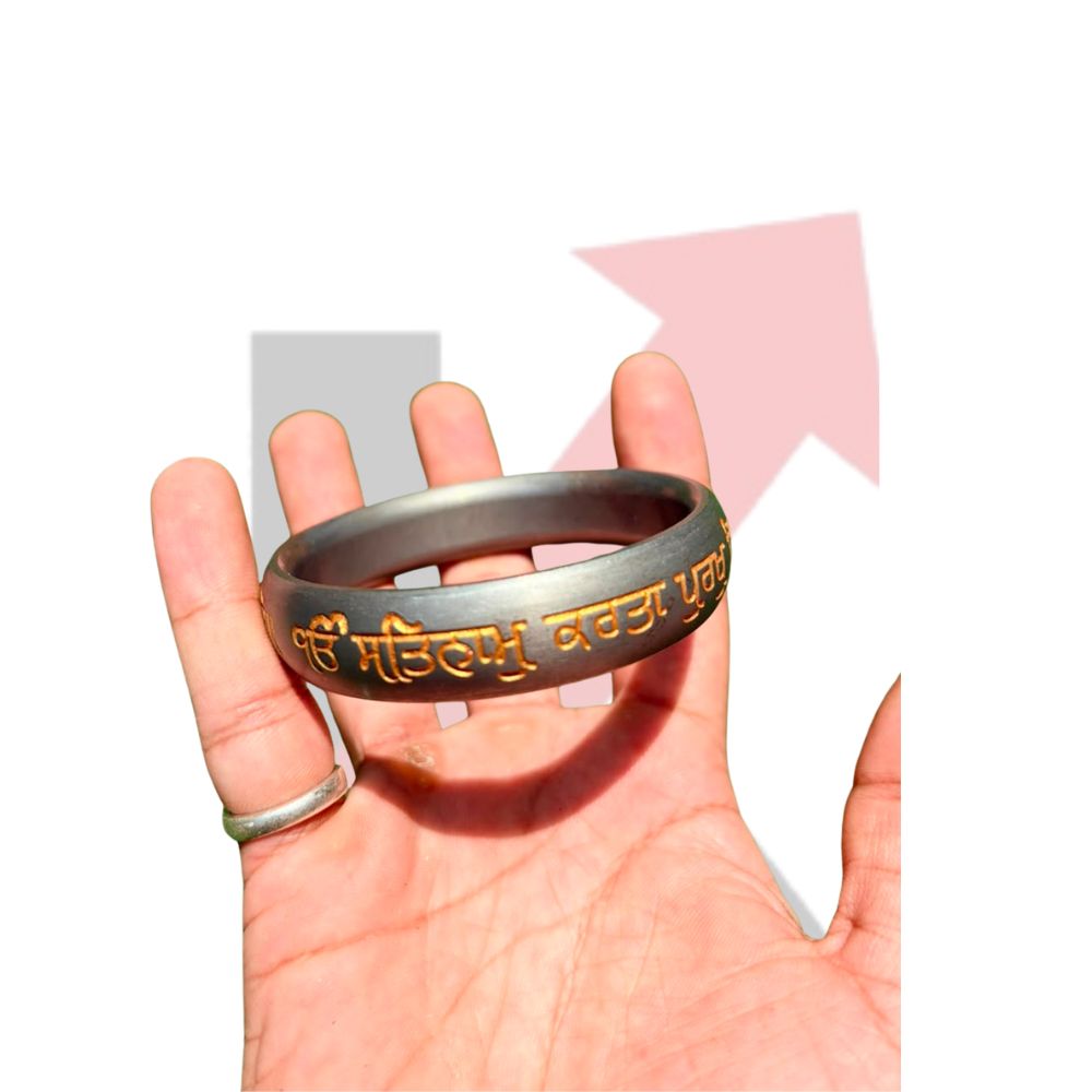 Close up of hand chiseled Mool Mantar engraving on iron kada