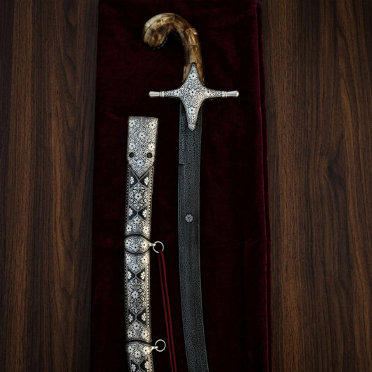 Close-up of a handcrafted Arabian sword with engraved metal hilt being held, showcasing traditional craftsmanship and premium ceremonial weapon design.
